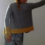 Aran weight, raglan cardigan with thumb openings and contrast colour border at cuffs and hem. Designed by Isabell Kraemer.