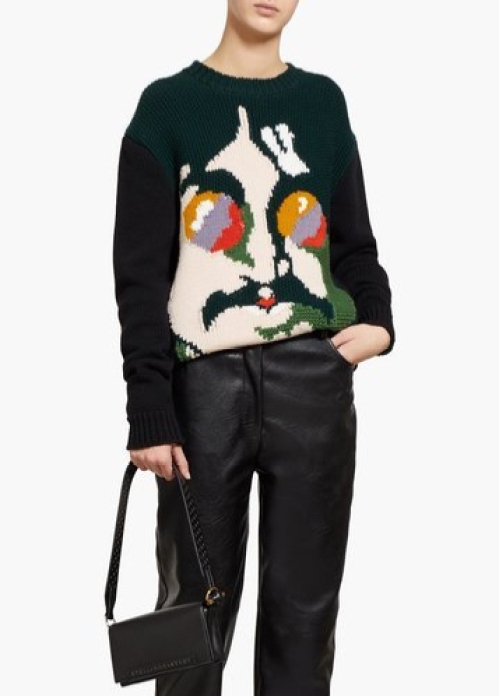 Woman wearing knitted sweater with all-over, multicoloured intarsia design of John Lennon.