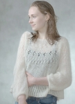 Woman wearing lightweight, knitted, oversized sweater with lace detail across yoke.