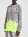 Woman wearing oversized, knitted sweater with all-over lace repeats, with the main body and sleeves in grey and third of body fading into neon yellow.