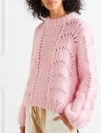 Model wearing pink, chunky knit sweater with panels of fan lace and mesh. Ganni Summer 2019.