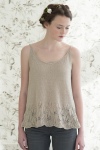 Model wearing pale beige tank top, with scoop neck, knitted in linen, and with pretty lace detail at hem. Pattern by Pam Allen.