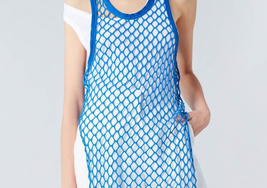 Model wearing Sonia Rykiel Blue, openwork mesh lace tank top over white vest and white, white legged trousers. Summer 2019.