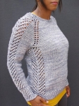 Knitwear designer Jimenez Joseph wearing knitted, crew neck sweater with striking eyelet lace details along side seams, shoulders and sleeves.