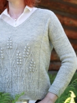 Reverse stocking stitch, knitted sweater with textured floral design.