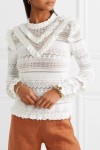 Model wearing white, cotton blend, crochet knit jumper with lace panels and ruffle details at neck, shoulders and lower arm.