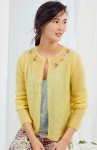 Model wearing mohair, knitted cardigan in warm yellow, with multicoloured, floral embroidery detail at neckline.