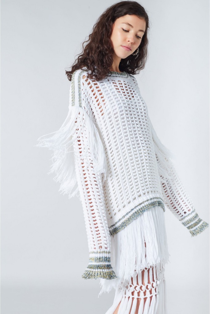 Model wearing Sonia Rykiel White knitted, oversized, white dress with allover mesh and fringe detail at back and hem.